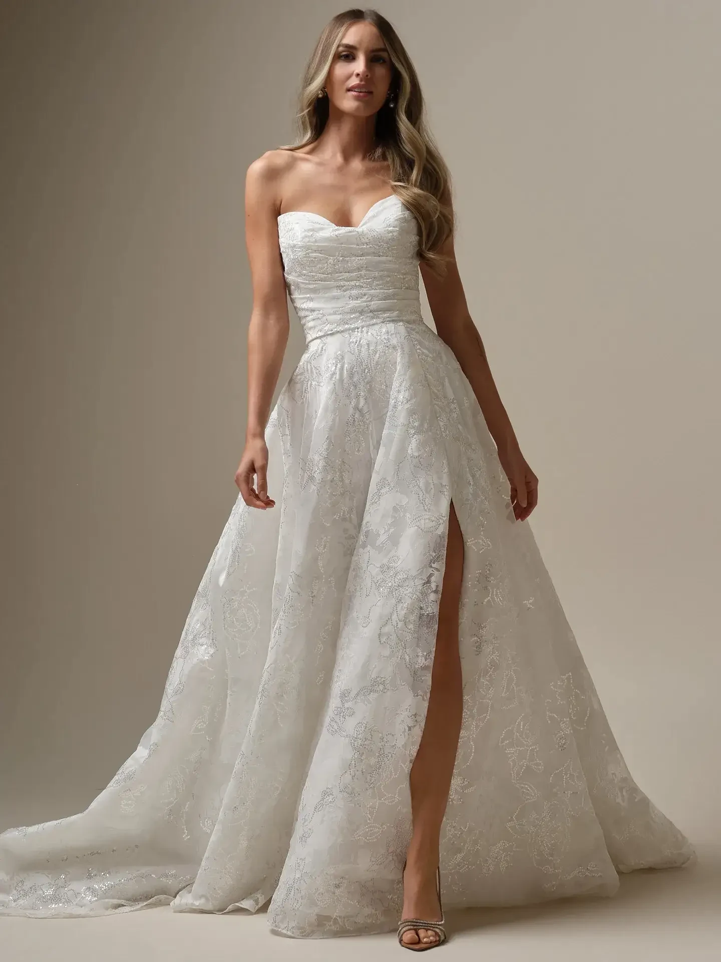 Model is wearing a strapless a-line organza and lace wedding gown