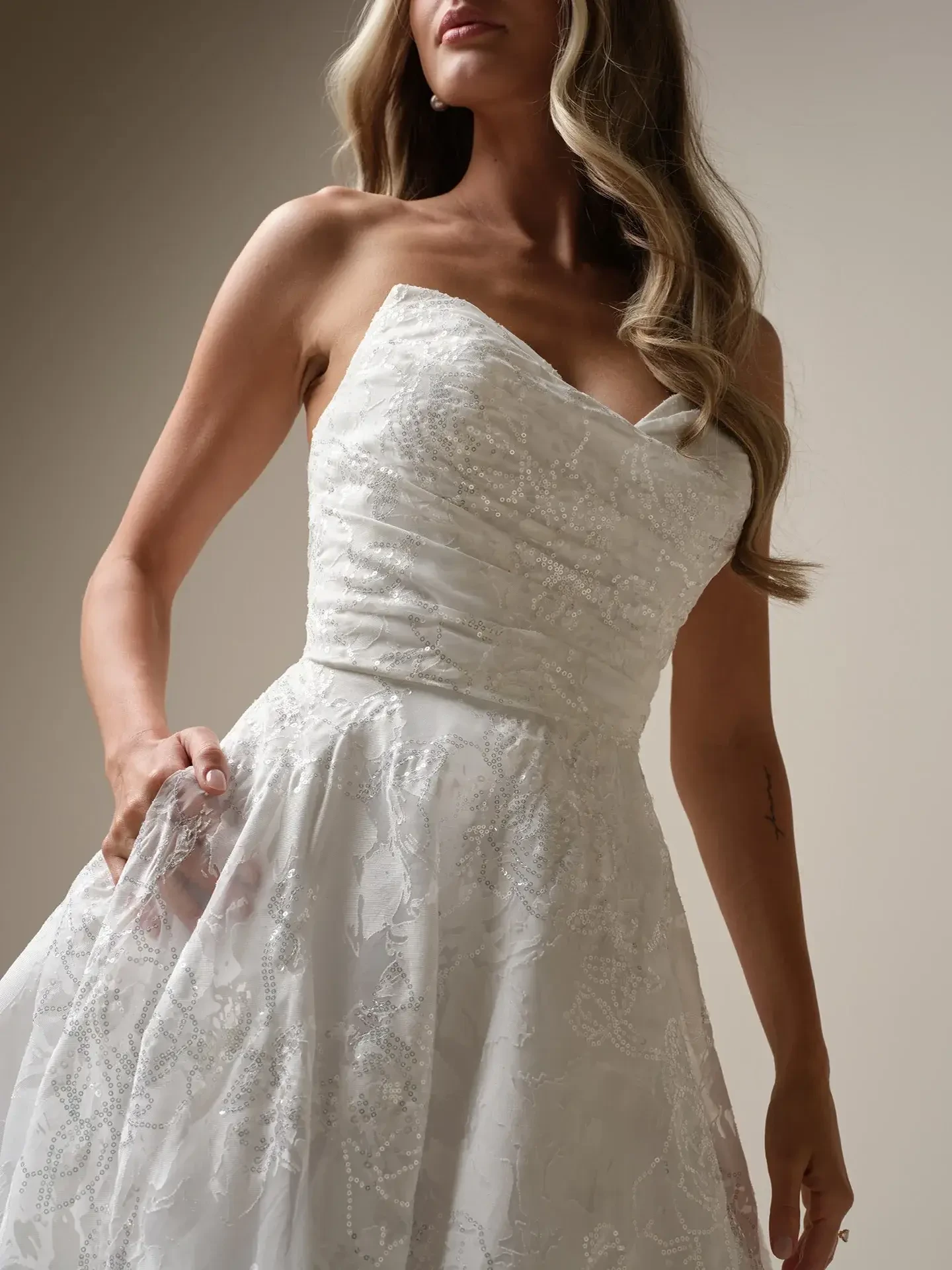 Model is wearing a strapless a-line organza and lace wedding gown
