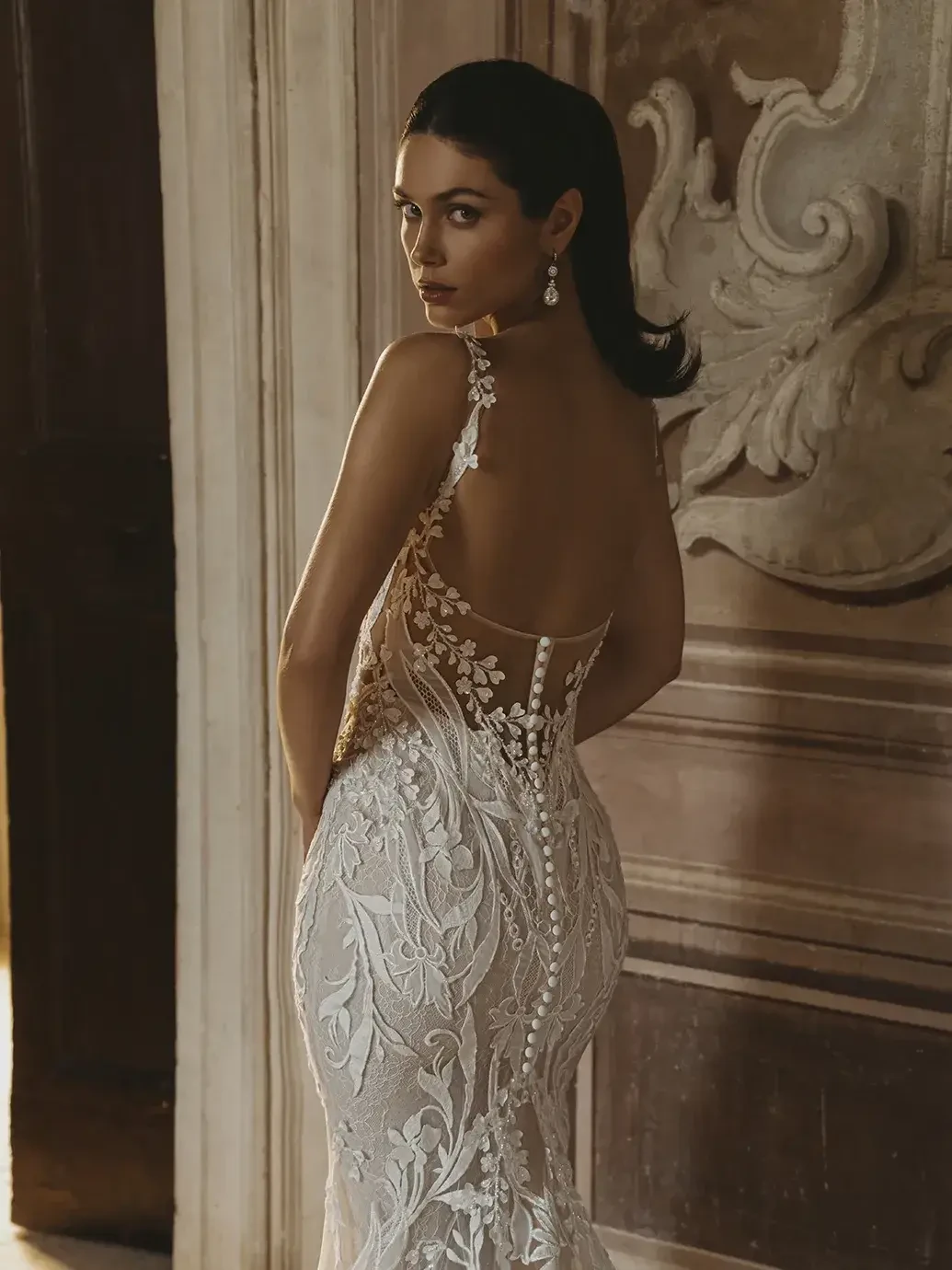 Model is wearing a fitted lace square neckline bridal gown