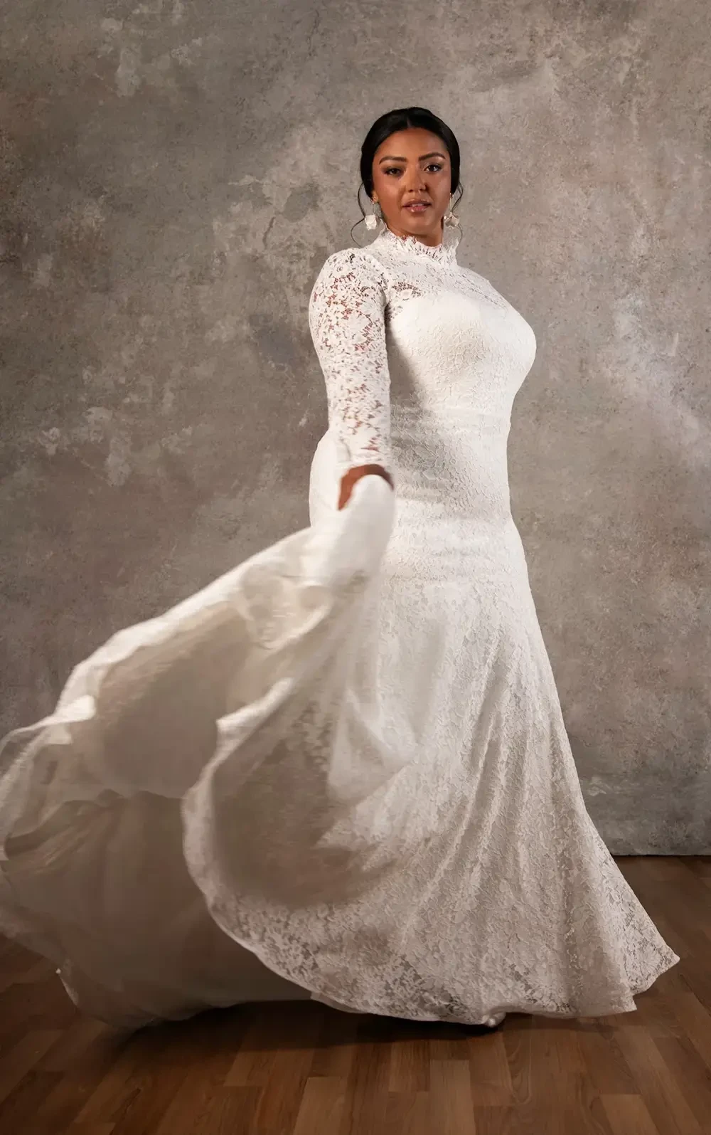 model is wearing a lace high neck long sleeve bridal gown