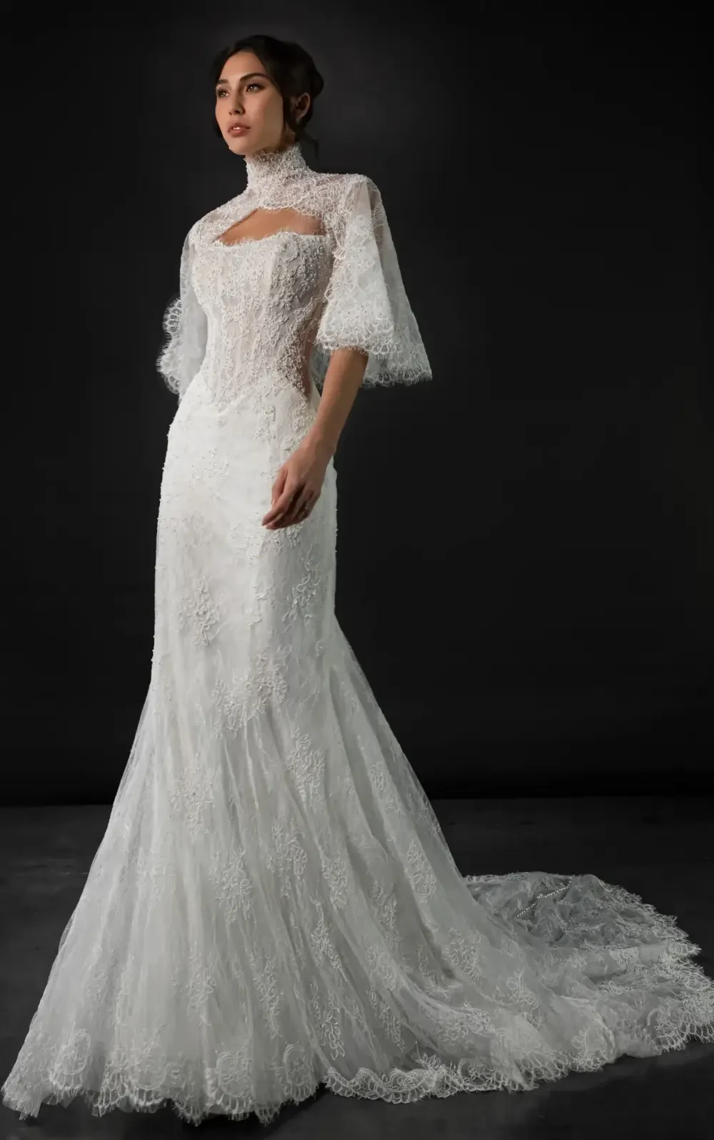 model is wearing a lace wedding dress with a lace high neck jacket